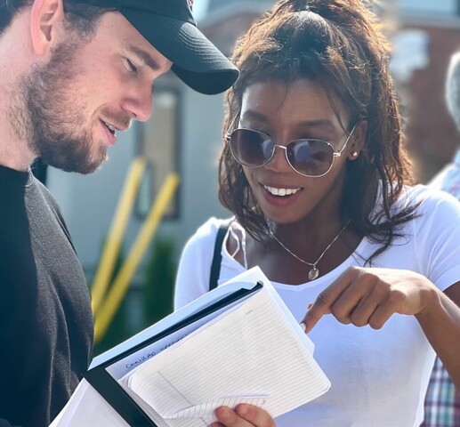 Two people talking and looking at a notebook