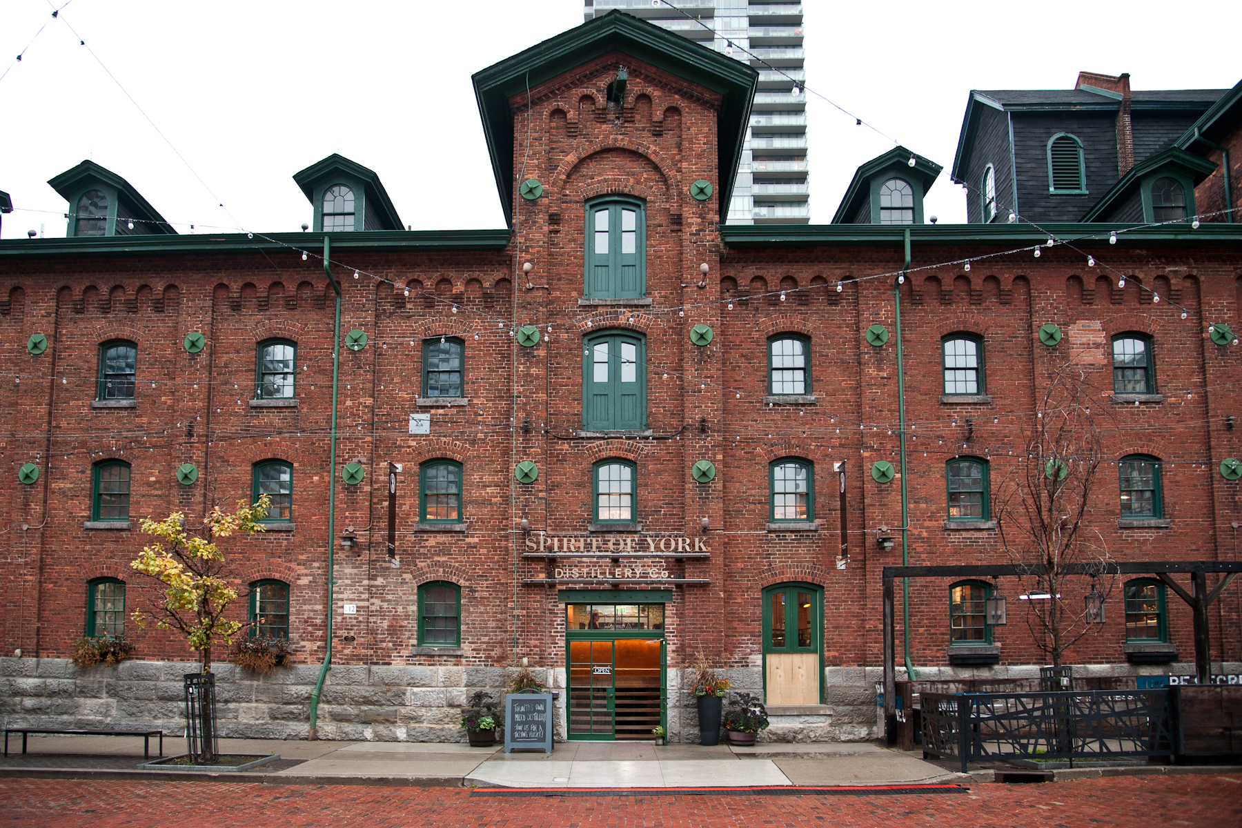Image of 19th century red-brick Victorian building. Large central tower-like feature serves as the entrance.