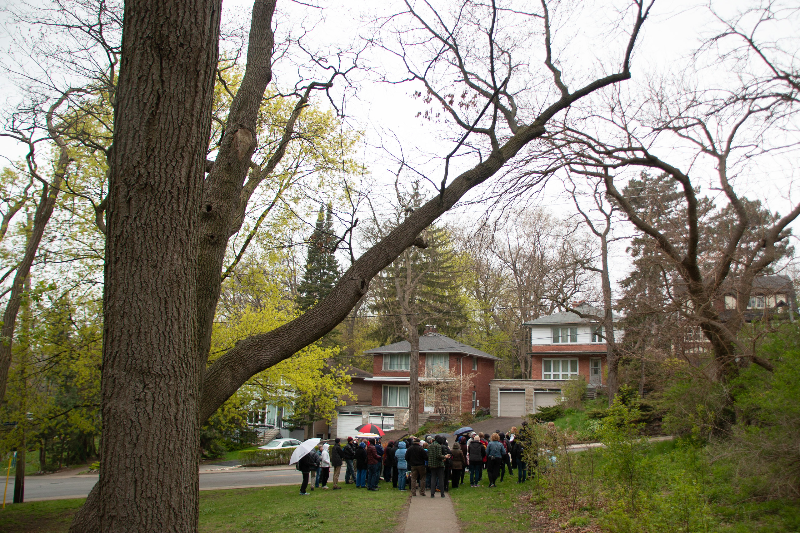 Image of a group standing together in the rain looking at a house