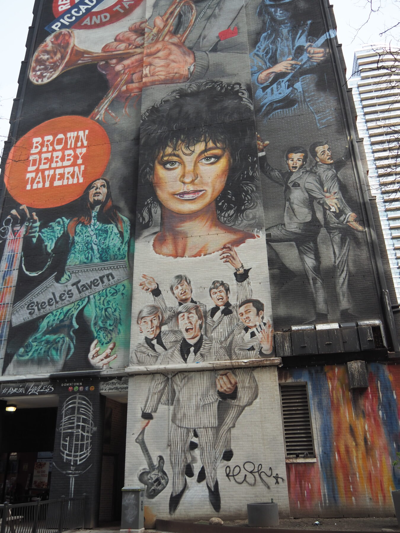 A tall mural painted with the likenesses of people
