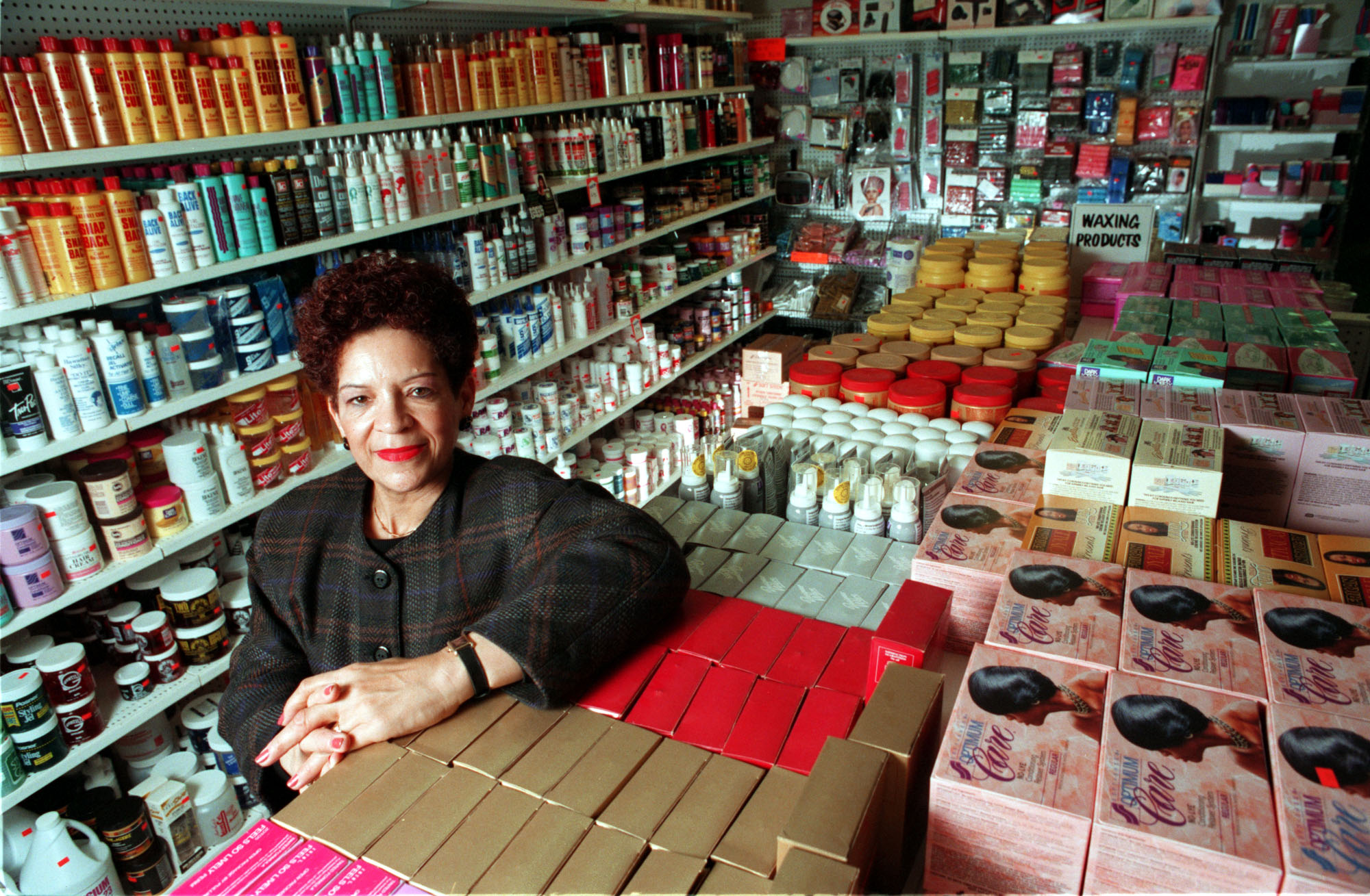A woman stands in a store crowded with beauty products.