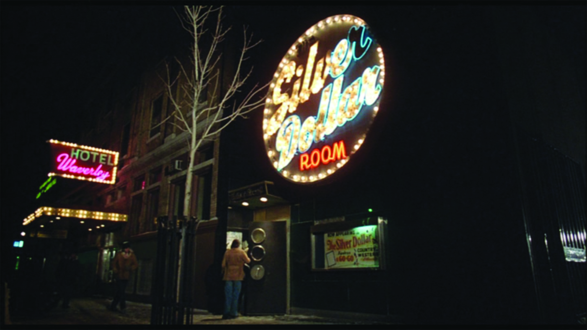 A still from the movie The Silent Partner showing the exterior of the Silver Dollar Room and the Hotel Waverley at night.