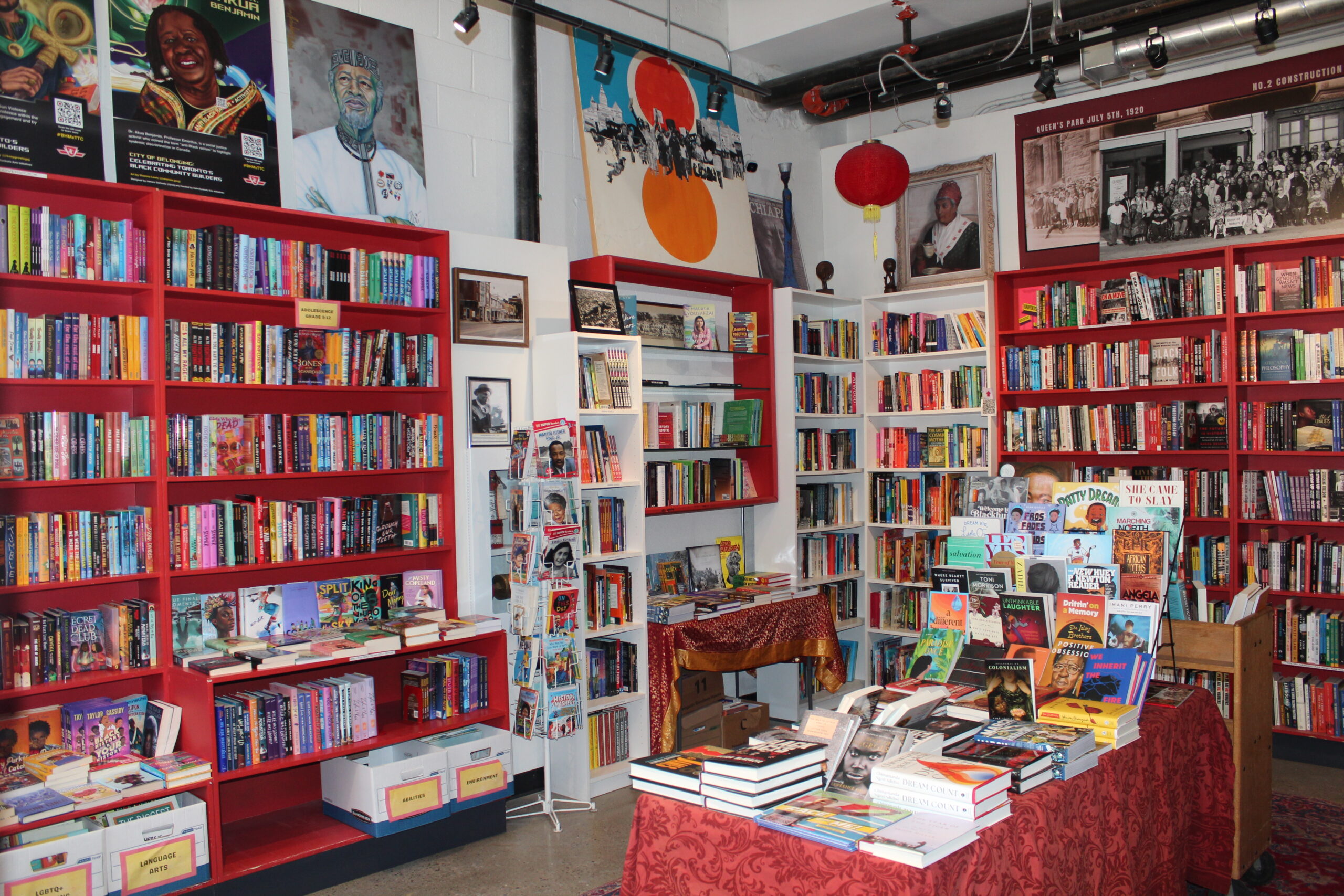 Interior of a bookstore with red shelves and many posters.