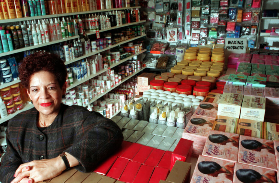 A woman stands in a store crowded with beauty products.