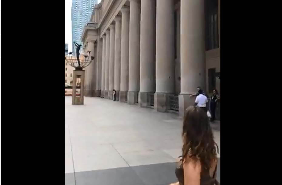 Screen shot of live stream showing collonaded building facade and monument.