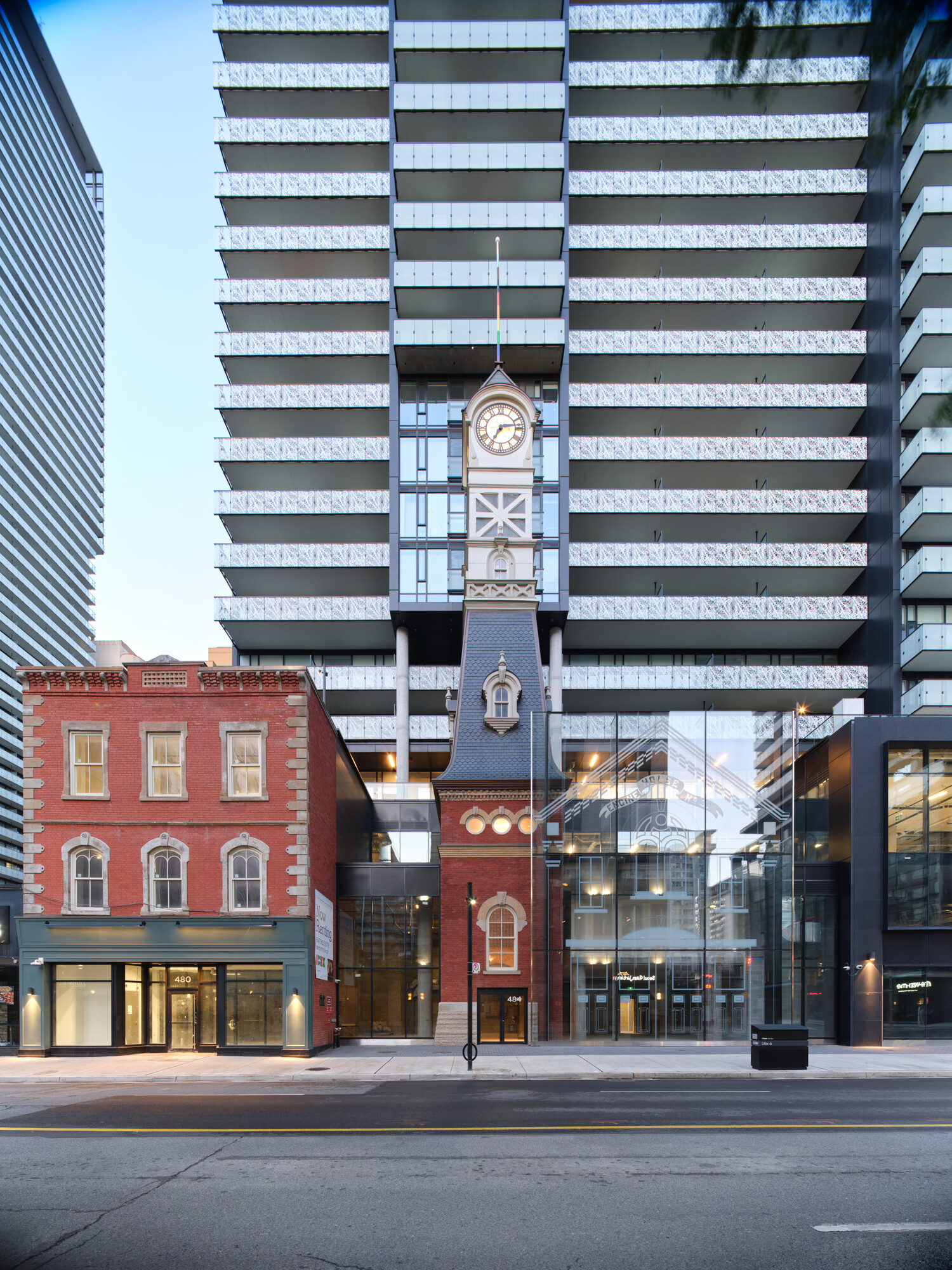 Corner view of IMMIX showing restored heritage elements at the base and a towering residential structure above.