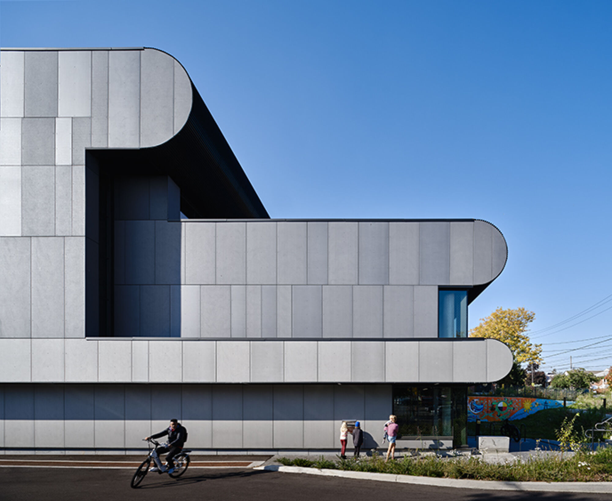 Exterior image of a grey-silver building with a curved roof and sides.