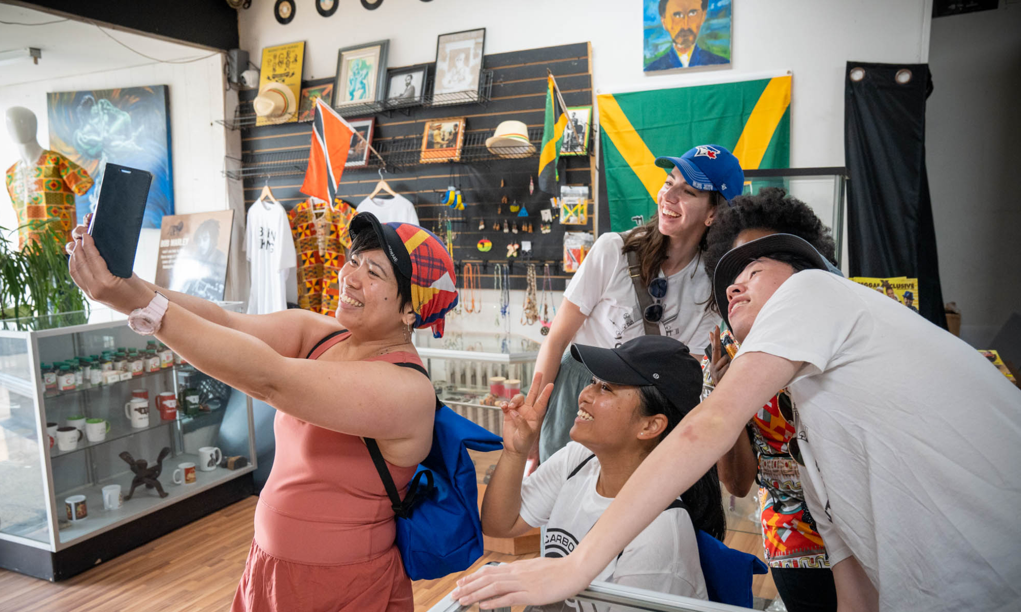 A group of people pose and take a selfie in a store with various displays along the walls and in cabinets.