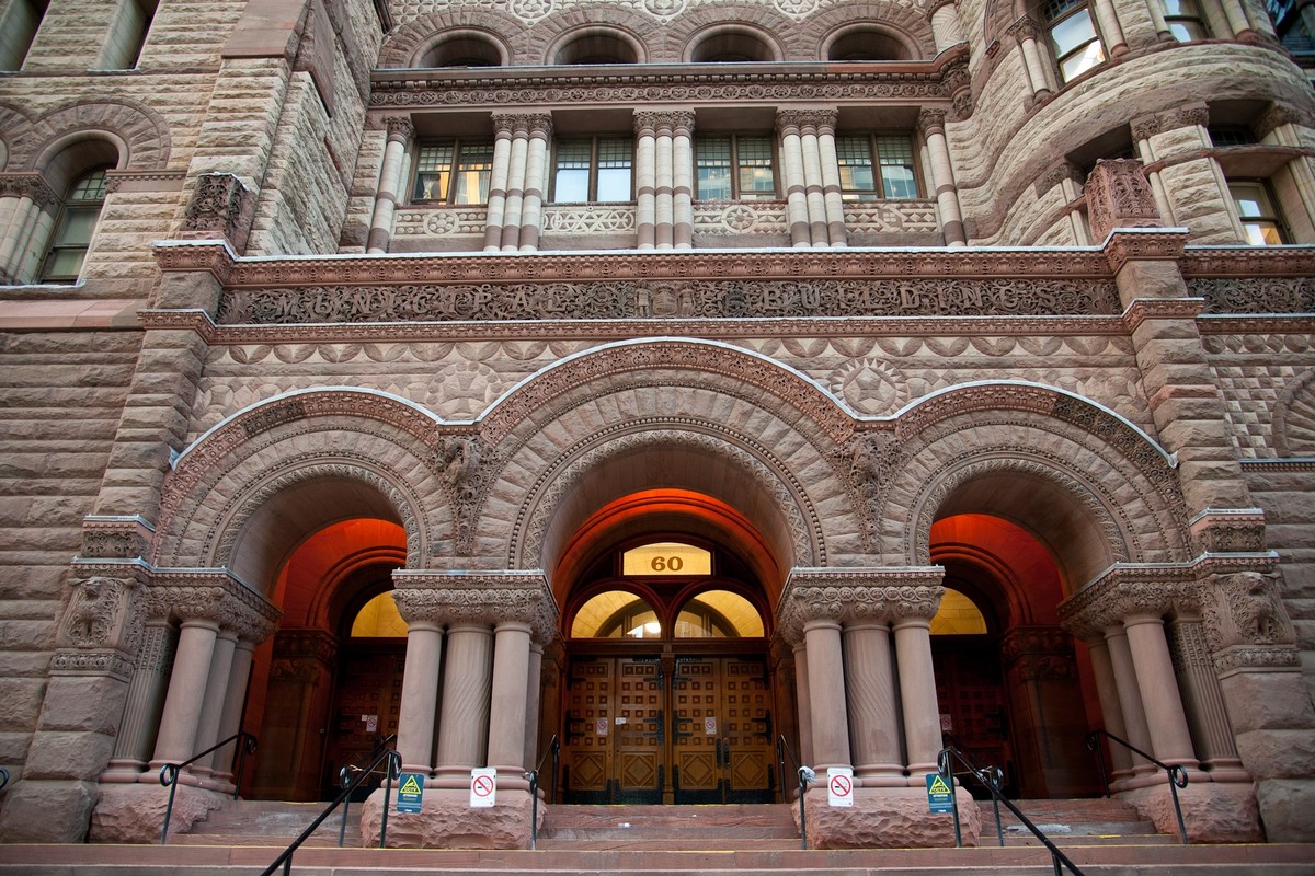A large building that represents the Romanesque Revival architecture style, which features curved entrance ways, large stone, and ornate decoration.