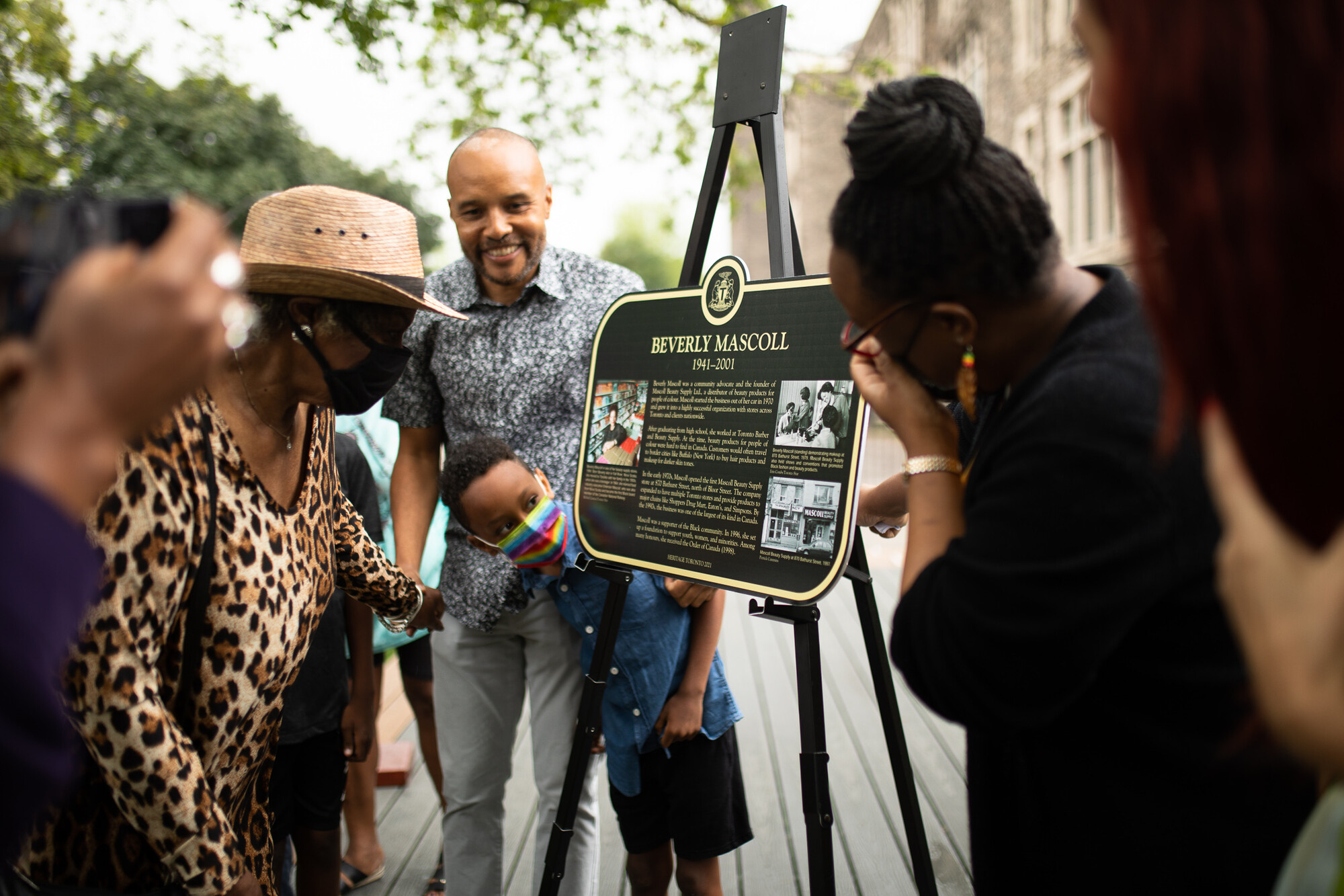 A group reads a newly-unveiled historical plaque on an easel