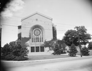Black and white image of a synagogue with trees around it.